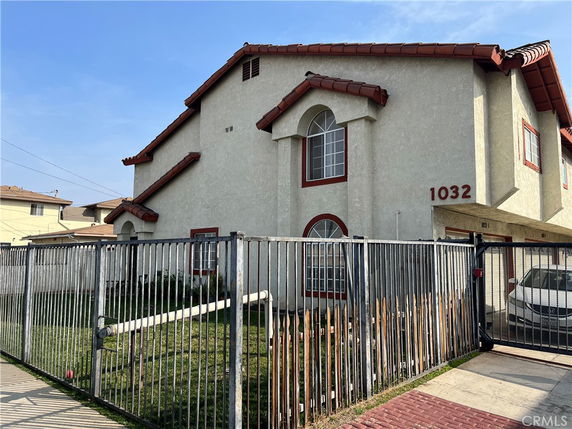 Front view of a two-story house with a gated entrance.