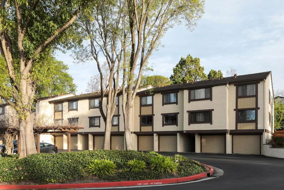 Front view of a three-story apartment building with multiple garages.