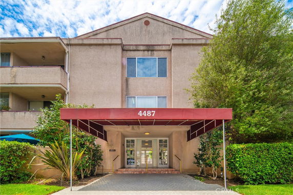 Front view of a multi-story residential building with a covered entrance.