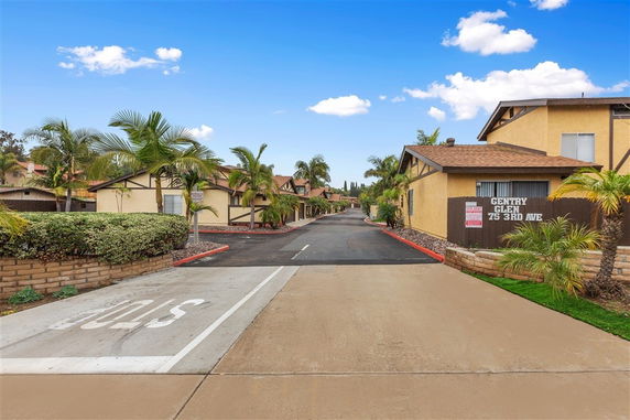 Front view of a residential building with multiple units and a driveway.