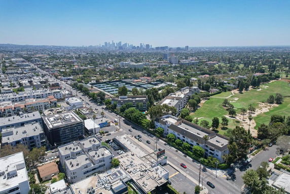 Panoramic view of a cityscape with buildings and green park areas.