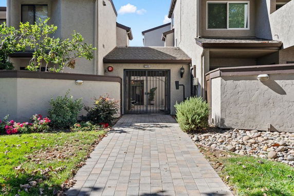 Front view of a multi-story house with a gated entrance.