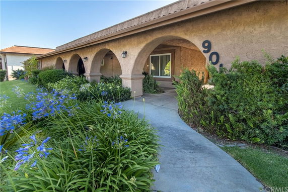 Front view of a single-story house with arched entryway and garden path.