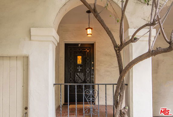 Front view of entrance door with an arched doorway and decorative metalwork