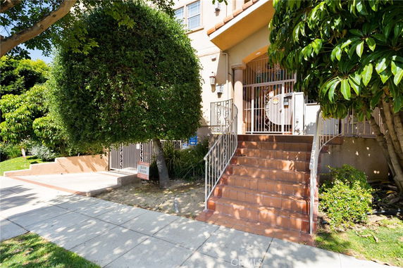Front view of a building with a staircase leading to the entrance.