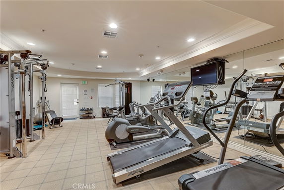 Indoor gym area with exercise equipment, including treadmills and weight machines.