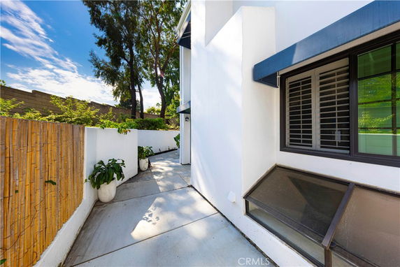 Side view of a house with a modern window design and a small patio area.