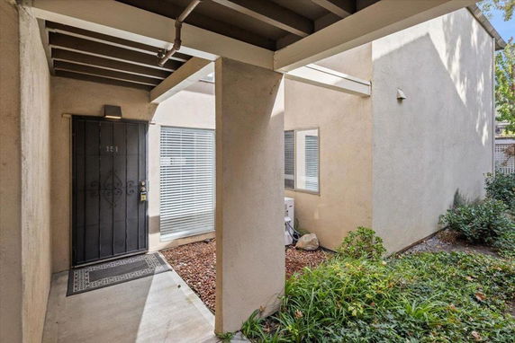 Front view of a house entrance with a black door and windows.