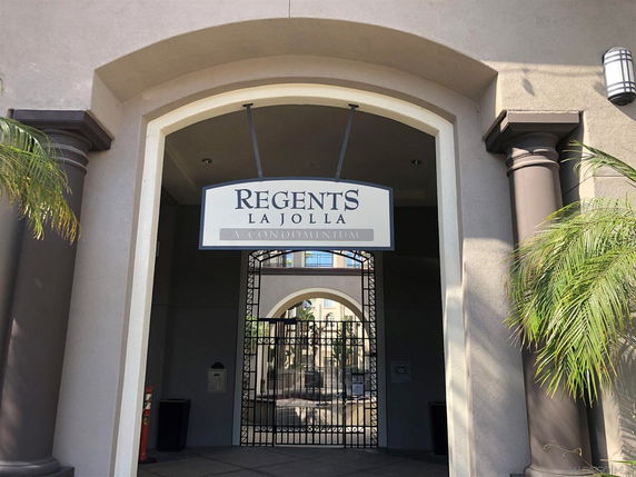 Front entrance of a condominium with a sign reading 'Regents La Jolla'.