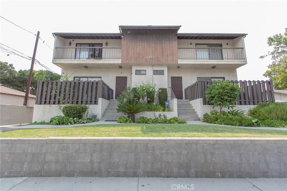 Front view of a two-story residential building with two entrances and balconies.