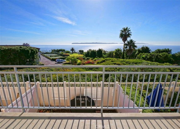 Panoramic view of the ocean and distant island from a building's balcony.
