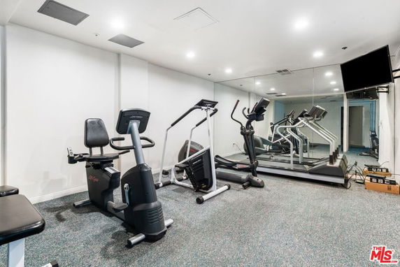 Indoor gym area with exercise equipment and a wall mirror.