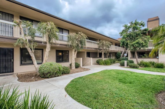 Front view of a two-story building with balconies and landscaping.