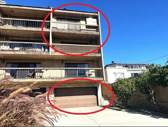 Front view of a multi-story apartment building with balconies and a garage.