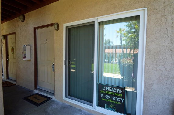 Entrance view of a building with a sliding glass door and regular door.