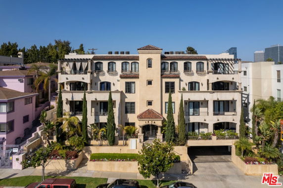 Front view of a multi-story residential building with Mediterranean architectural style.