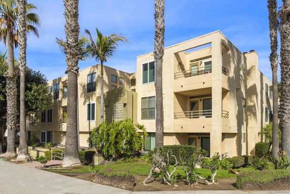 Front view of a multi-story apartment building with balconies.