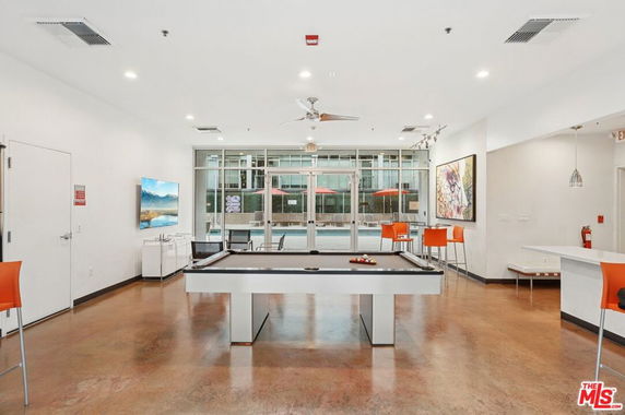 Interior of a club house room with a pool table and seating area.