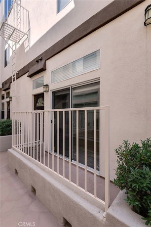 Rear view of a building with a sliding glass door and exterior stairs.