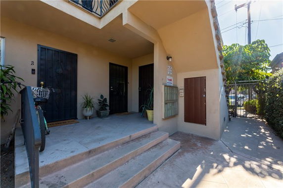 Front view of a building entrance with steps and two doors.