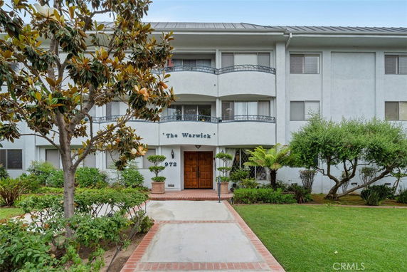 Front view of a three-story building with a central entrance and balconies.