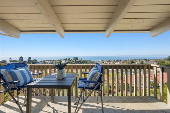 Wide angle view of the surrounding area from a balcony, overlooking a landscape and sea in the distance.