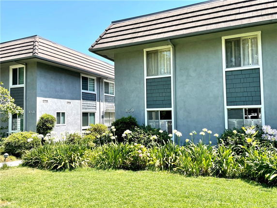 Front view of a multi-story building with a landscaped garden.