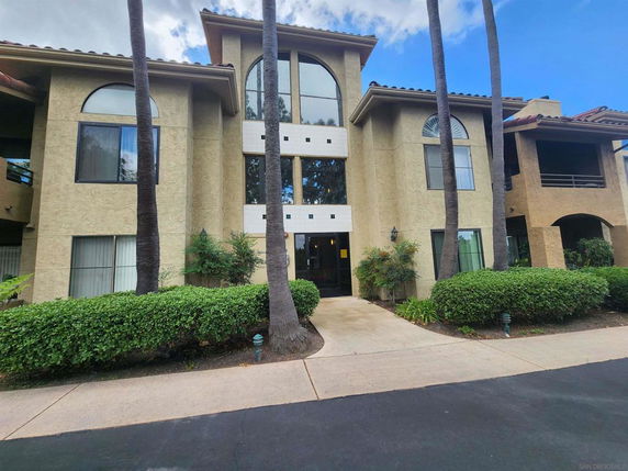 Front view of a multi-story building with arched windows and a central entrance.