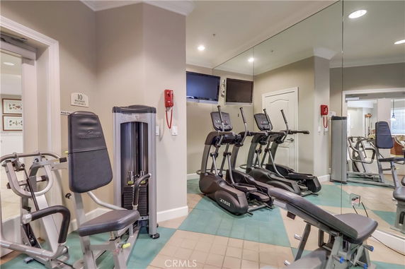 Indoor gym area with exercise machines and mirrored walls.