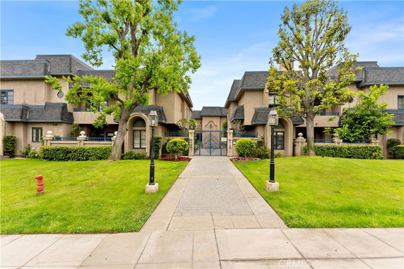Front view of a residential building with an arched entrance and decorative fences.