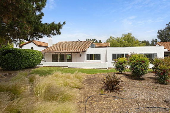 Front view of a single-story house with a white exterior and a red-tiled roof.