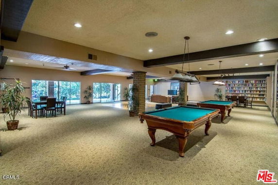 Indoor clubhouse area with pool tables and seating arrangements.