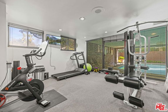 Home gym with exercise equipment, treadmill, and weights.