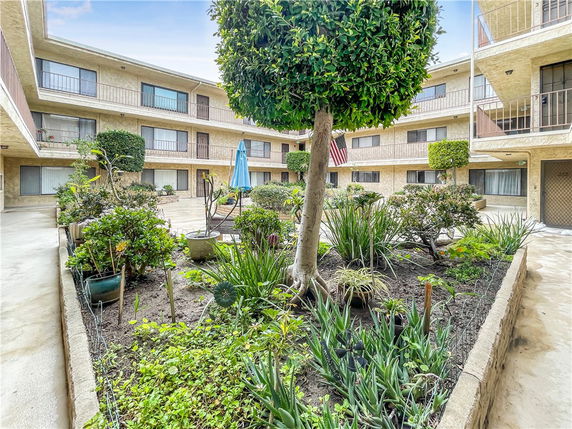 Exterior courtyard of an apartment building with a central garden feature.