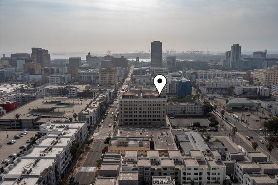 Aerial view of an urban area with various buildings and a distant view of a waterfront.