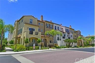 Front view of a multi-story townhouse with Mediterranean architectural style.
