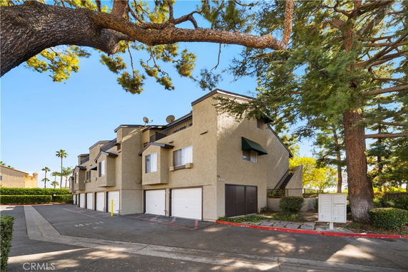 Front view of a multi-story residential building with garages on the ground level.