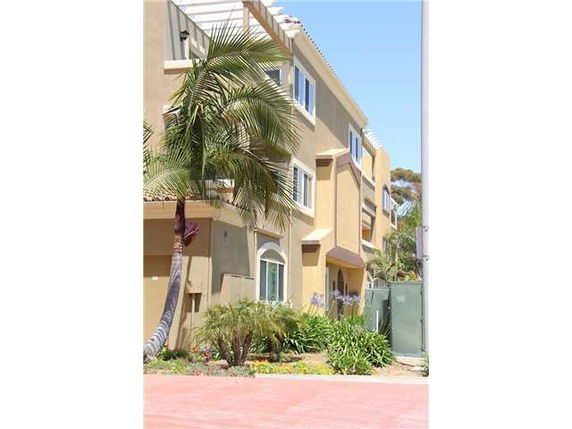 Front view of a multi-story building with palm trees.