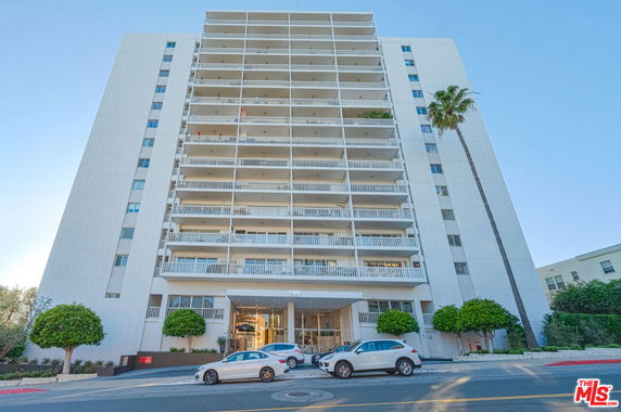 Front view of a multi-story apartment building with balconies.