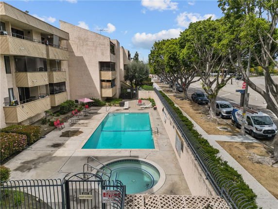 Outdoor swimming pool area with adjacent apartment building.