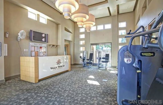 Interior view of a gym area with exercise equipment and a reception desk.