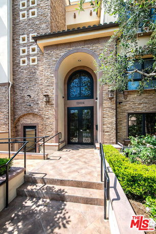 Front view of a multi-story building with stone facade and ornate front entrance.
