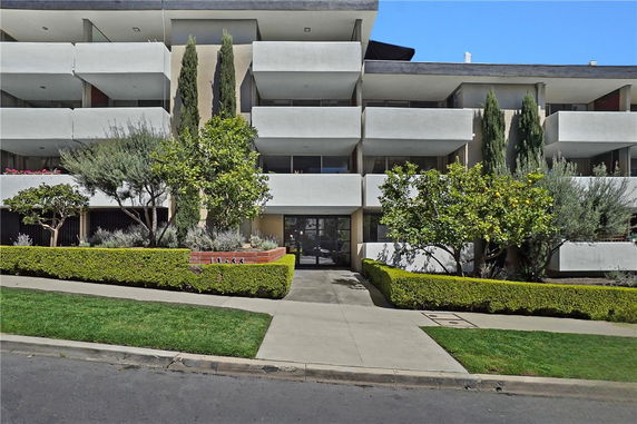 Front view of a modern multi-story apartment building with balconies.