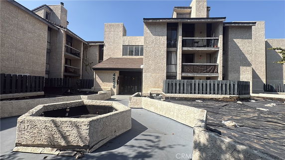 Front view of a multi-story apartment building with balconies.
