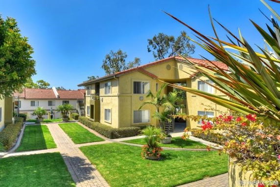 Front view of a two-story apartment building with a landscaped courtyard.