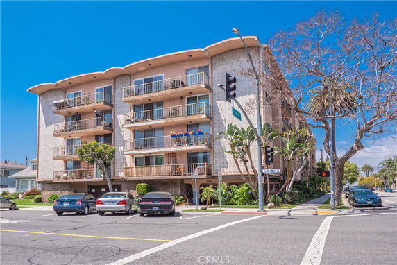 Front view of a multi-story apartment building with balconies.