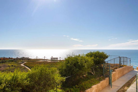 Panoramic view of the ocean with a pathway and seating area overlooking the water.