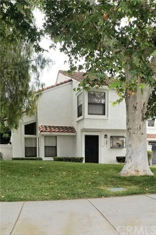 Front view of a two-story house with a tiled roof and beige exterior.