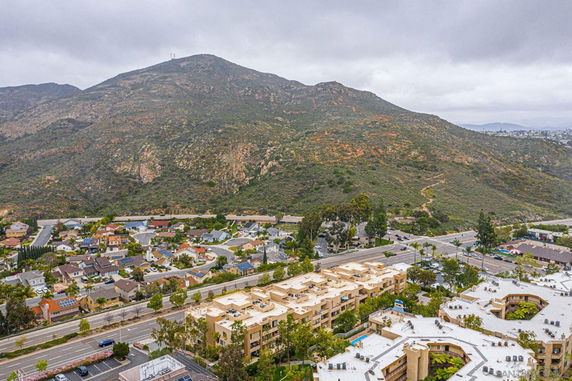 Aerial view of a residential area with surrounding hills and roads.