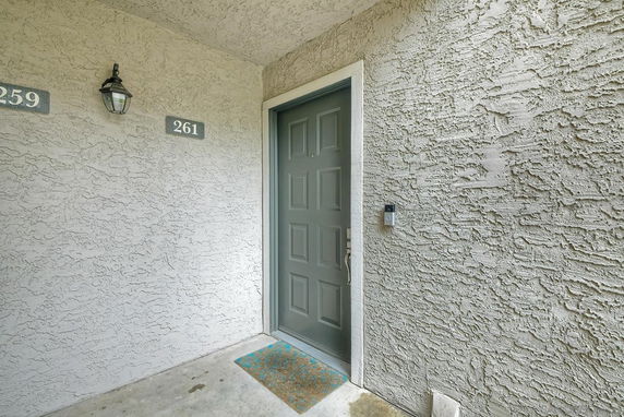 Entrance of a building with a gray door and textured walls.
